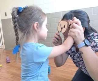 Una niña responde a una lámina con la imagen de un mono que le muestra la terapeuta